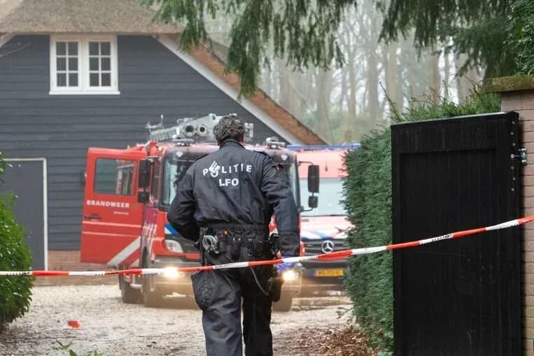 Afgezette crime scene van politie politie wandelt voorbij het lint en er zijn brandweer autos op de achtergrond